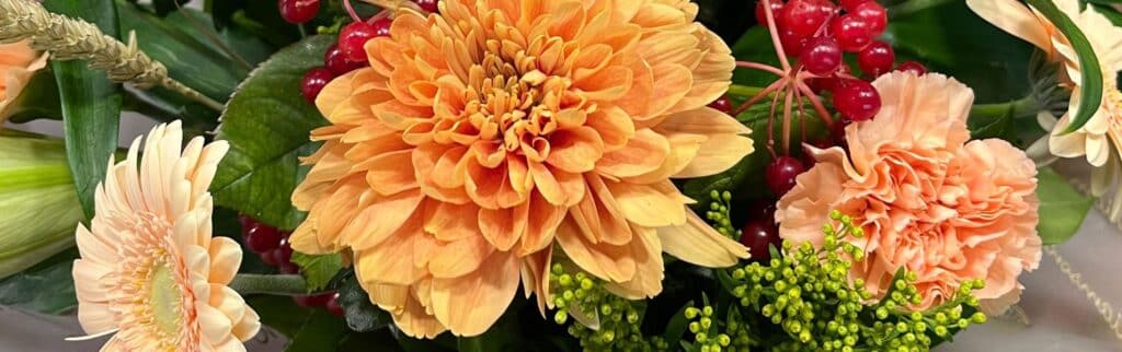 Best Autumn Flowers Autumn flower bouquet of orange and red flowers with green foliage and red berries