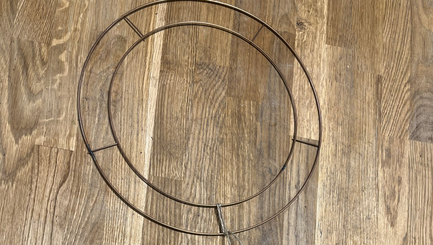 Christmas flower wreath wire frame on a wooden work surface