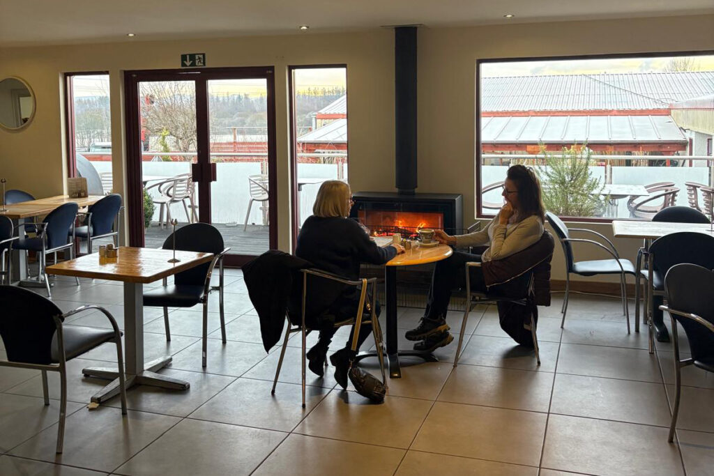Local customers enjoying coffee beside a log burner at Williamson's Coffee Shop in Livingston, West Lothian
