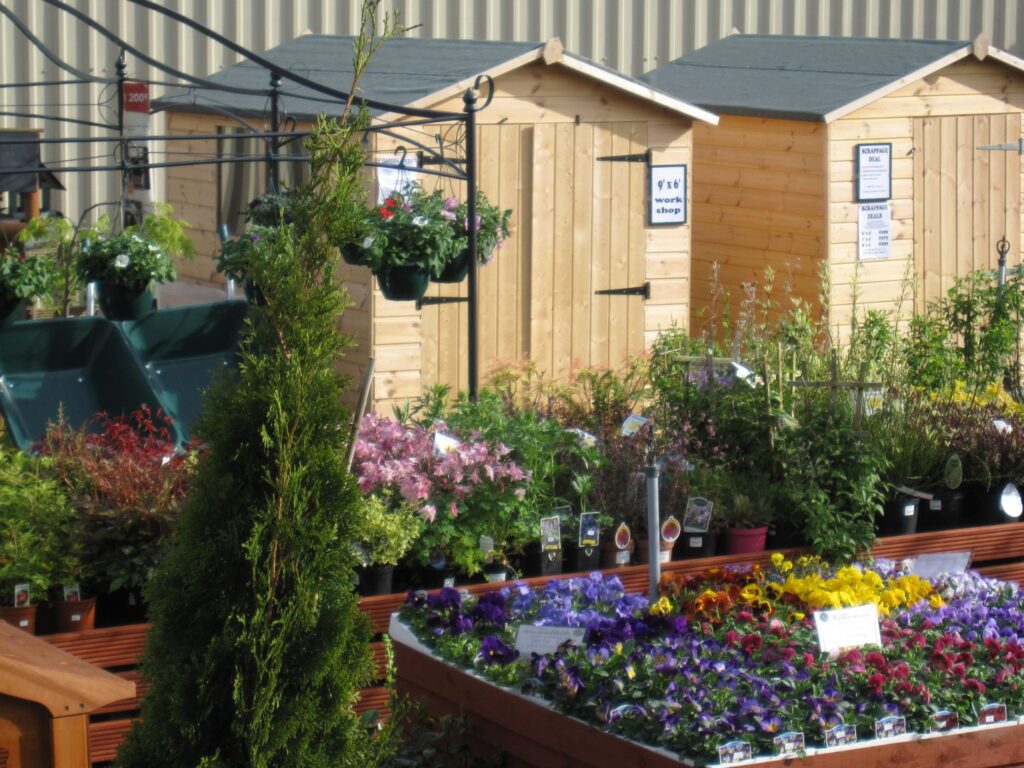 Outdoor plant displays with shrubs, small trees and wooden garden sheds at Williamson’s Garden Centre in Livingston, West Lothian.