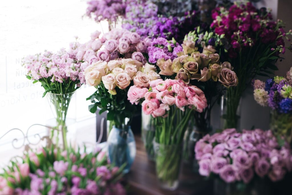 Fresh flower bouquets in glass vases at Williamson's florist shop in Livingston, featuring pink roses, ranunculus and stocks