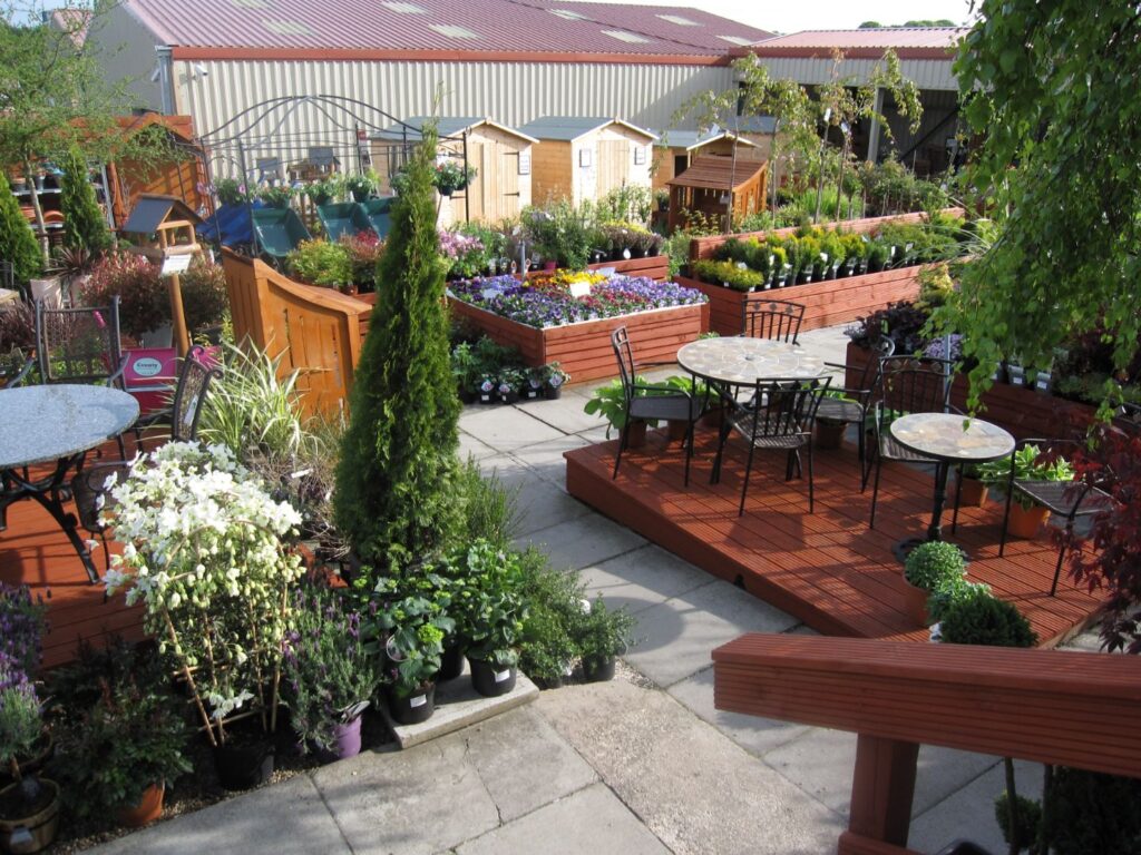 Outdoor garden centre area at Williamson's Livingston with raised planting beds, patio furniture and garden summerhouses for sale
