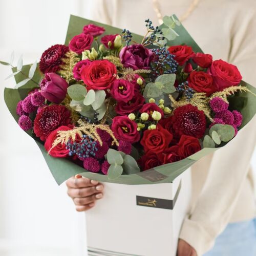 Festive Jewels Christmas bouquet with purple and red flowers, roses and seasonal greenery